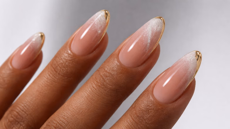 Minimalist nude nails with subtle gold tips on almond-shaped nails