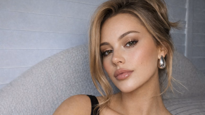 Woman with clean girl makeup look featuring natural glowing skin and soft neutral tones