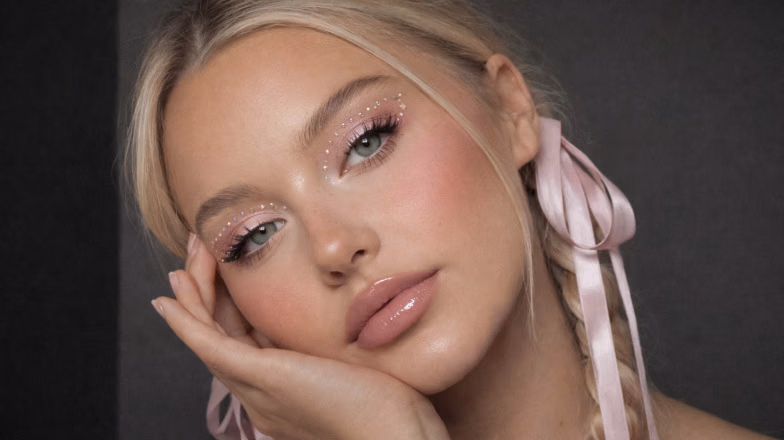 Woman with K-beauty inspired makeup featuring dewy skin and soft pink tones for a fresh youthful look