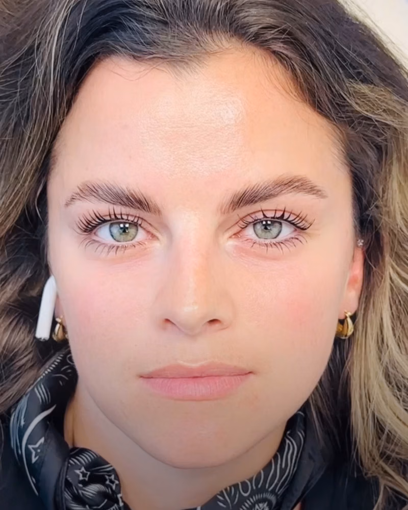 Close-up portrait showing neatly shaped brows after brow threading and lamination, with lifted brow hairs and a clean, polished finish