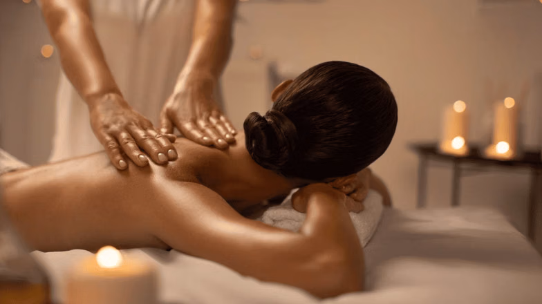Relaxing back massage in a spa setting with candles during first massage experience in Dubai
