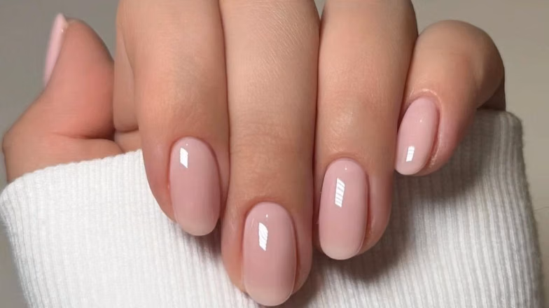 Classic nude manicure on natural nails with smooth glossy finish