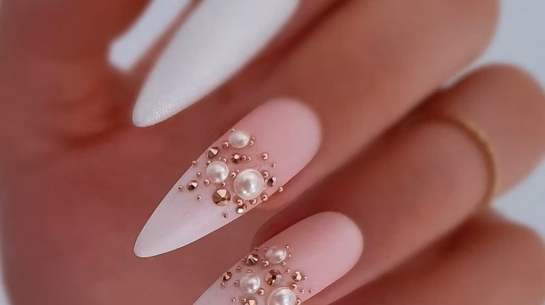 Soft pink nails with decorative rhinestones and elegant nail art design
