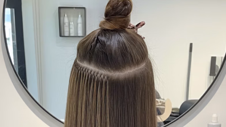Neatly sectioned hair prepared for extension installation in salon