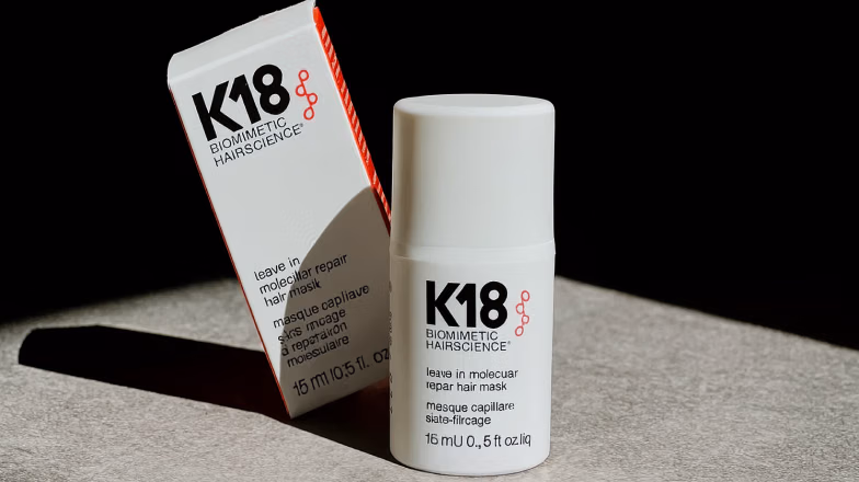 K18 leave-in molecular repair hair mask bottle and packaging on a dark background