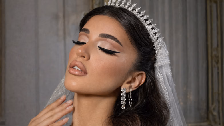 Soft glam bridal makeup look in Dubai with veil, glowing skin and defined eyebrows
