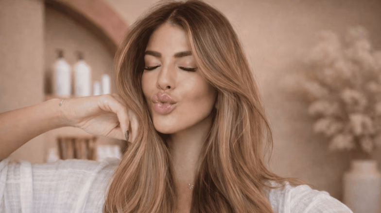 Voluminous balayage hair styled in soft waves with face-framing highlights