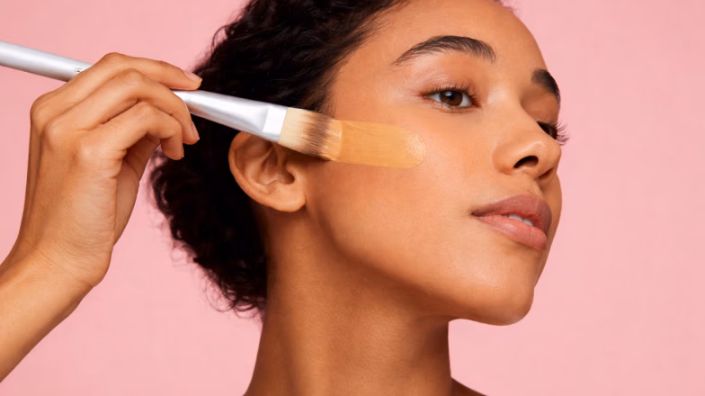 Applying liquid foundation with brush for smooth and even makeup base