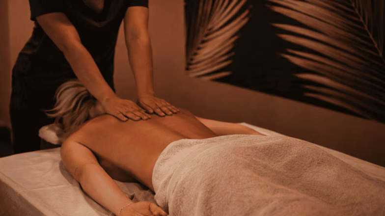 Spa massage experience with therapist performing relaxing back massage for first-time client